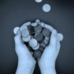 a person holding a bunch of coins in their hands