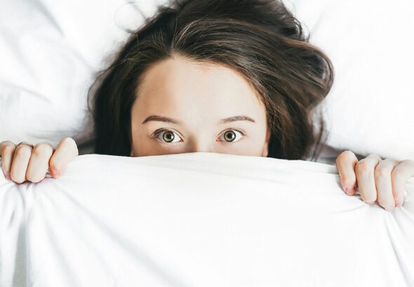 woman covering her face with blanket