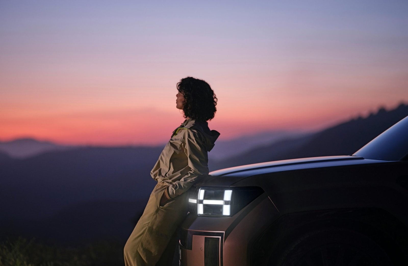 a woman sitting on the hood of a car: Electric Cars