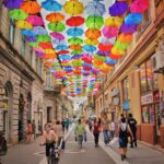 assorted-color umbrella hanged above pathway near houses