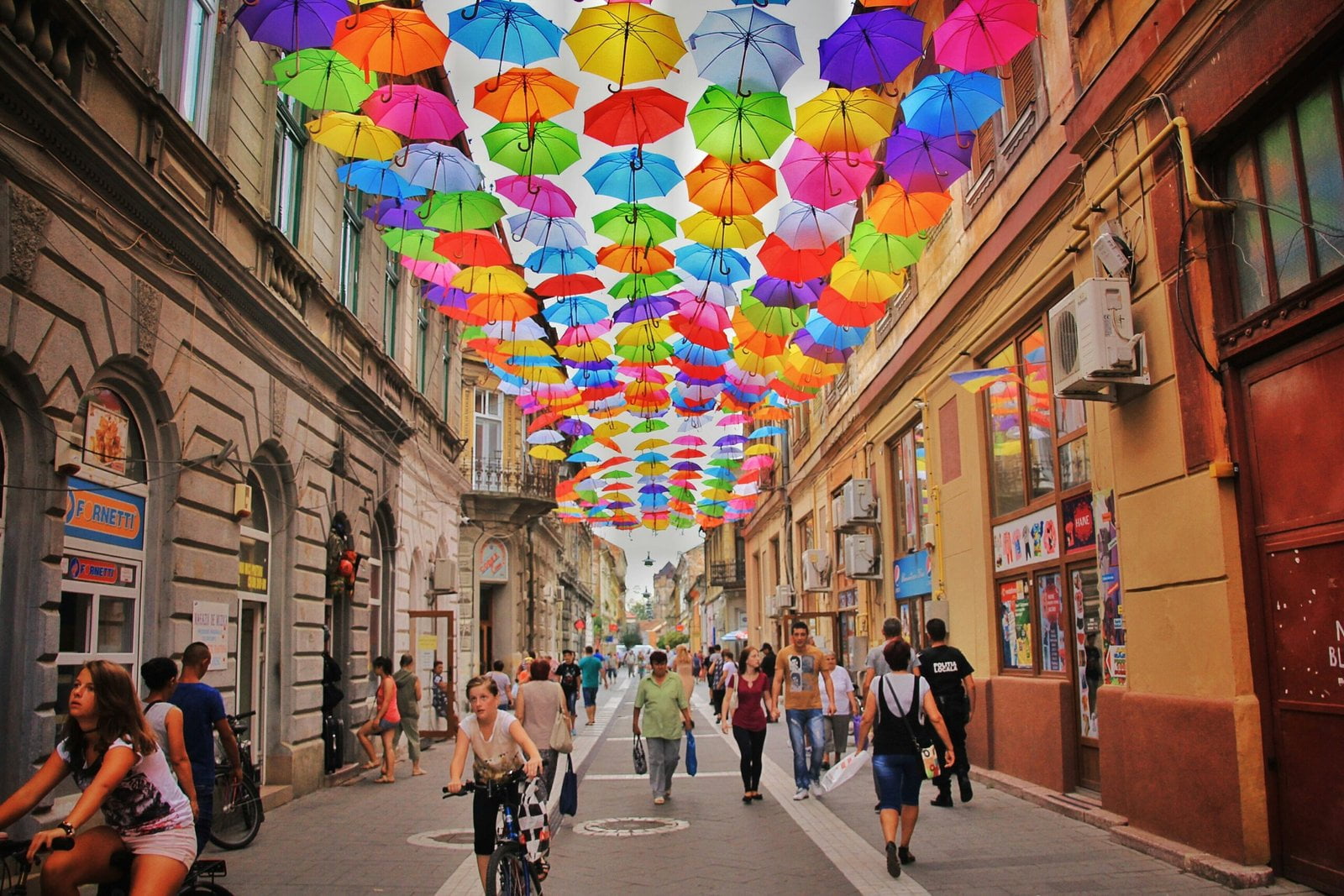 assorted-color umbrella hanged above pathway near houses: Culture and Heritage