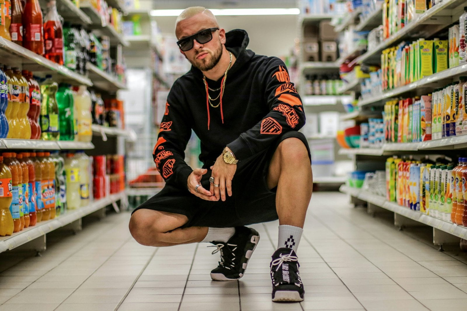 man squatting on floor between grocery items showing his Appearance 