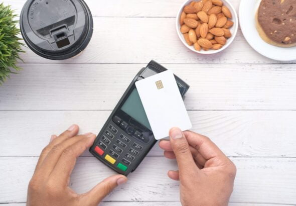 a person holding a credit card next to a calculator