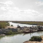 a group of people standing on top of a river