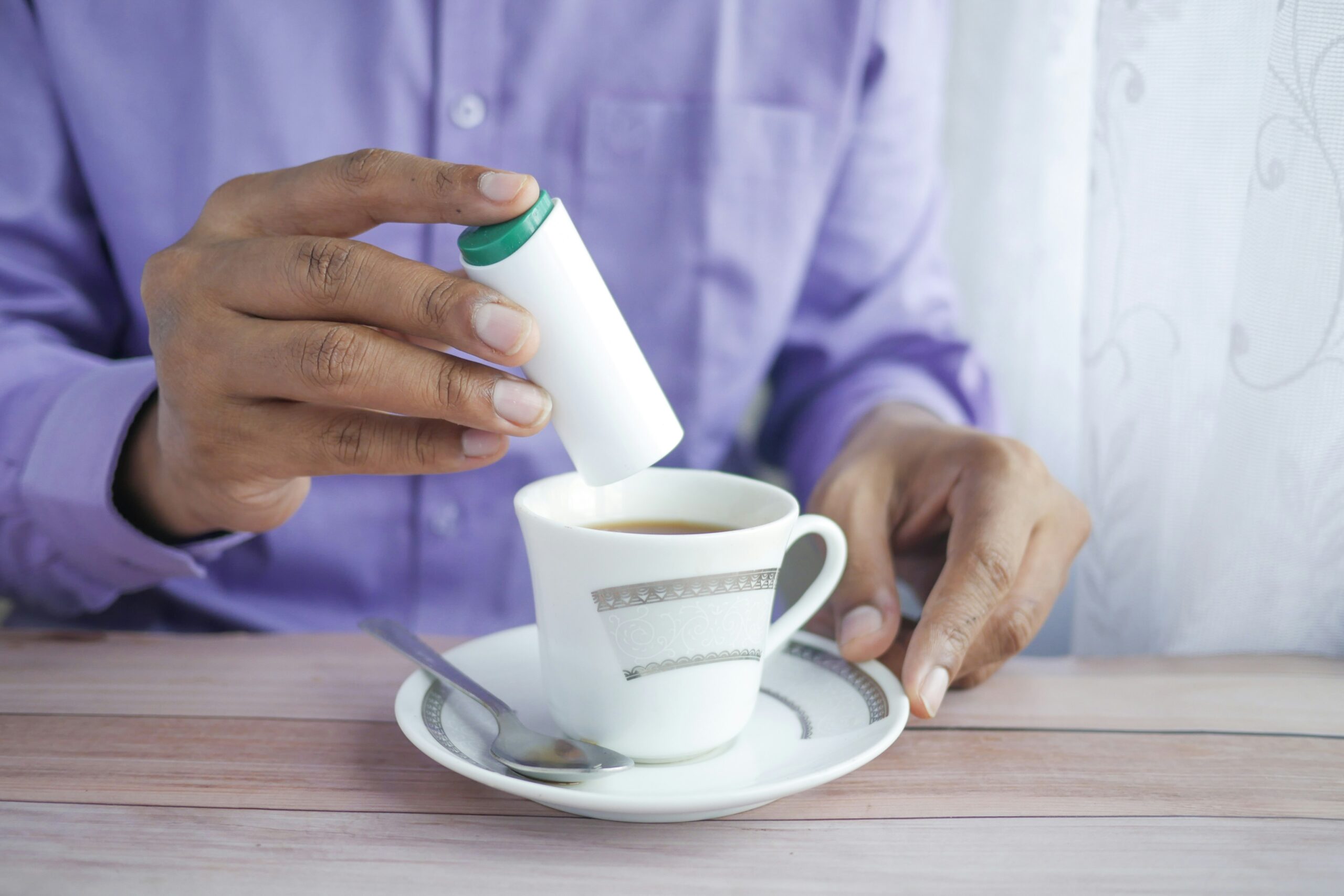 person holding white ceramic mug: The Danger of Sugar