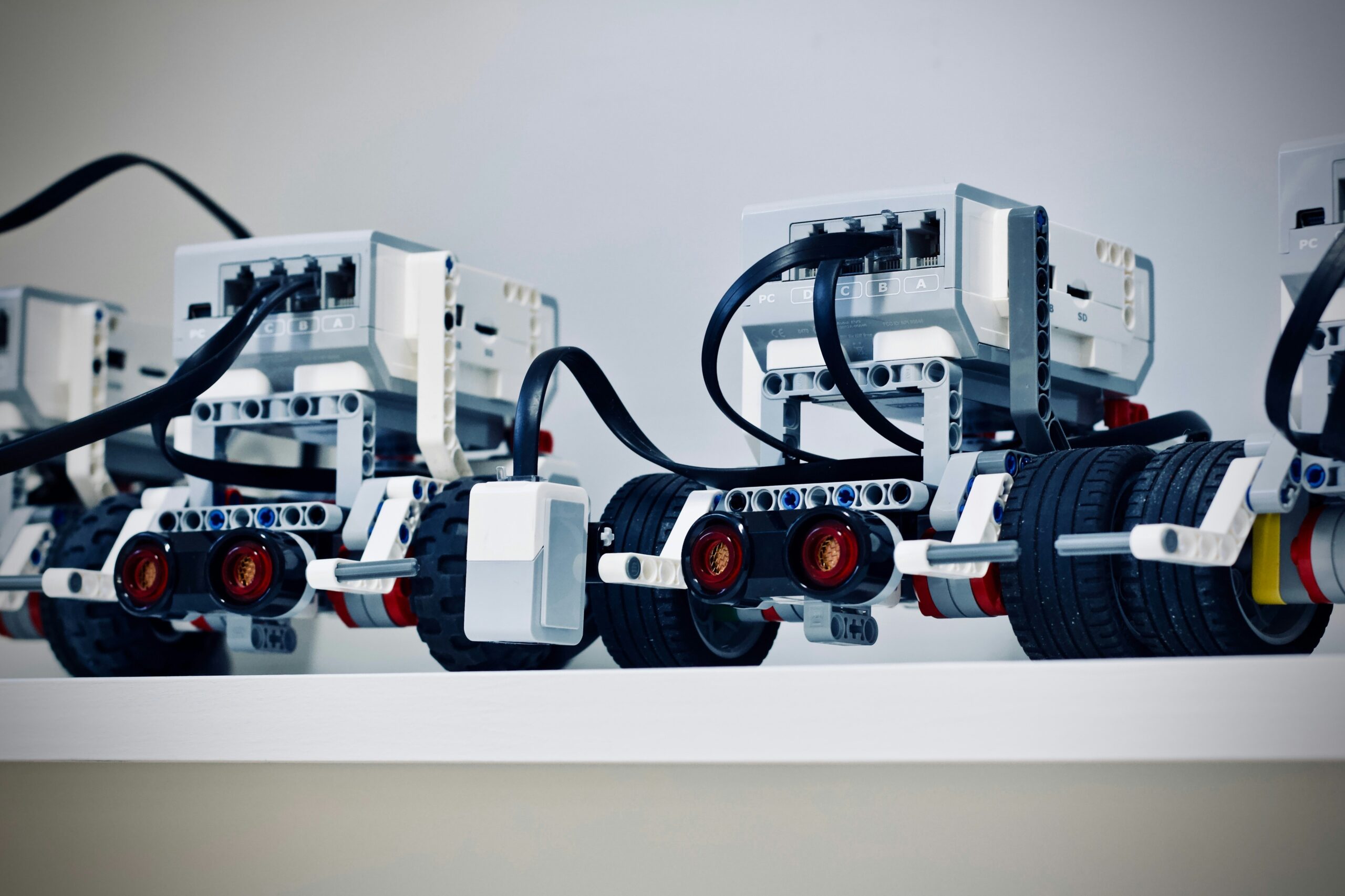 two white and black electronic Robots with wheels