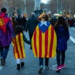 four person walking on road with flag capes