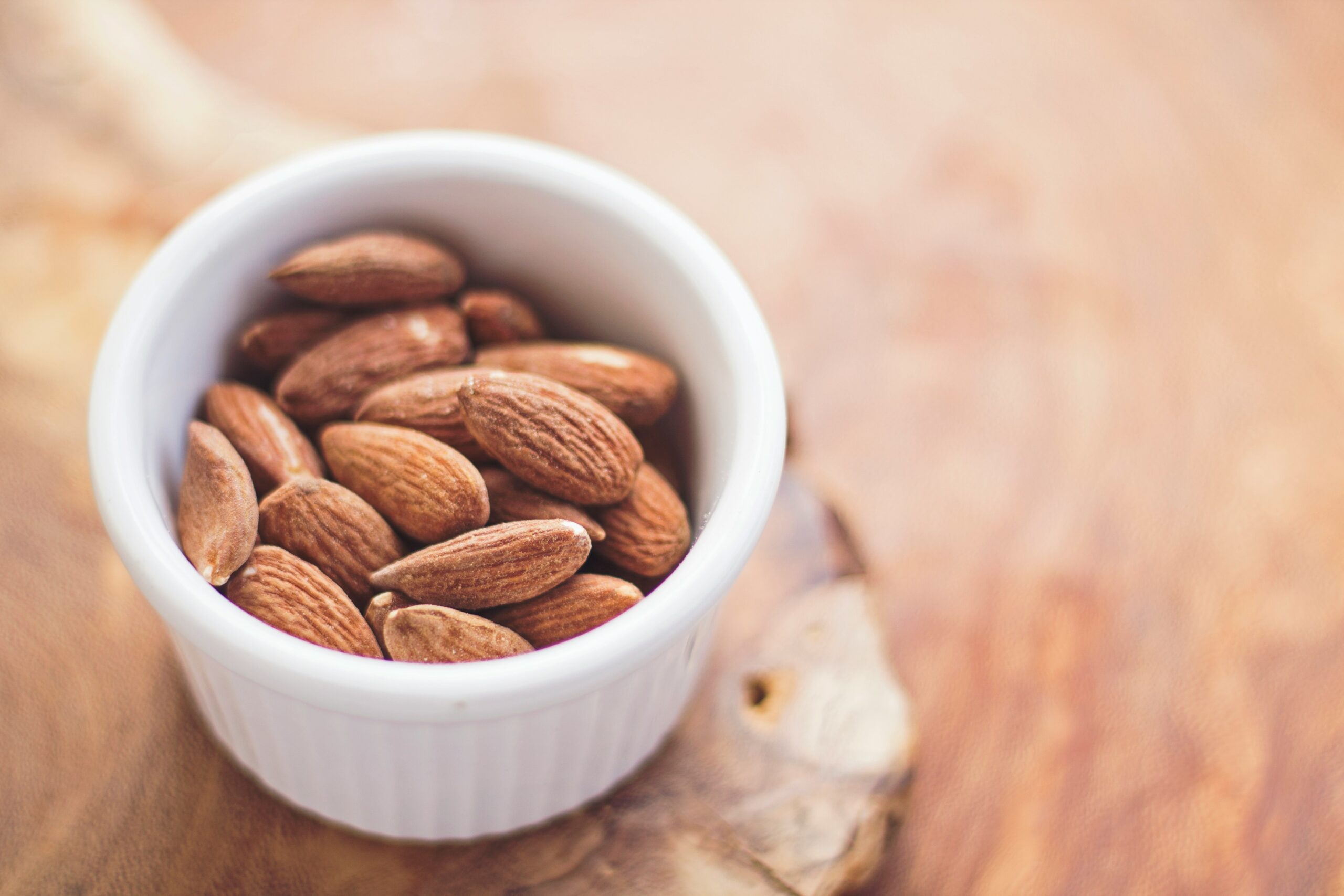 shallow focus photography of almonds in white ceramic bowl: Food Additives