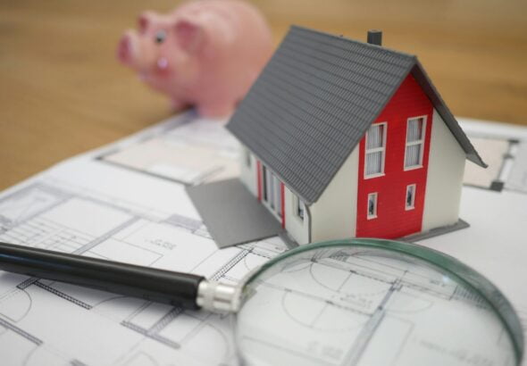 white and red wooden house beside grey framed magnifying glass