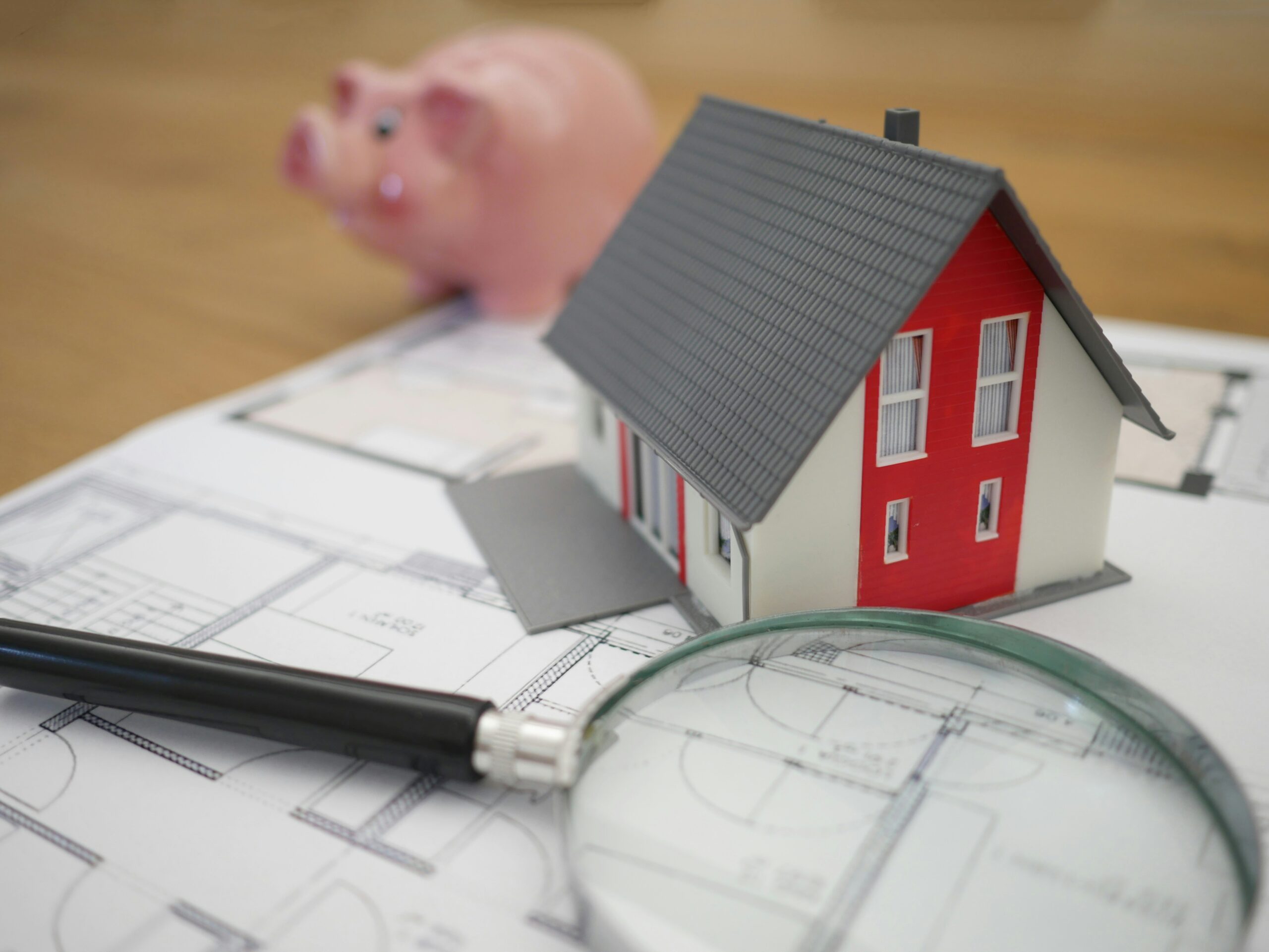 white and red wooden house beside grey framed magnifying glass: refer to the tensions in the Middle East