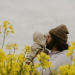 a man and woman kissing in a field of yellow flowers