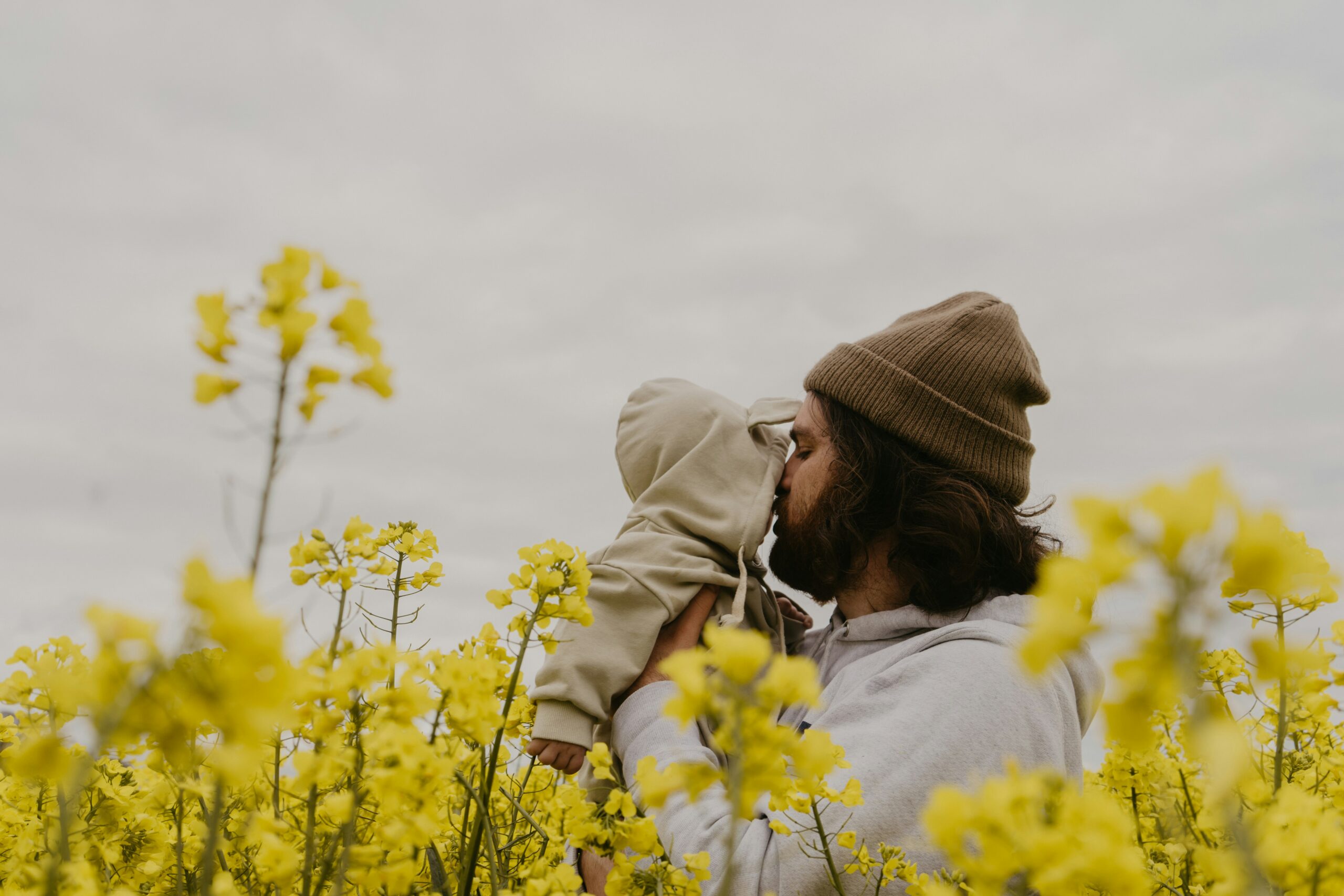 a man and woman kissing in a field of yellow flowers: Child Development